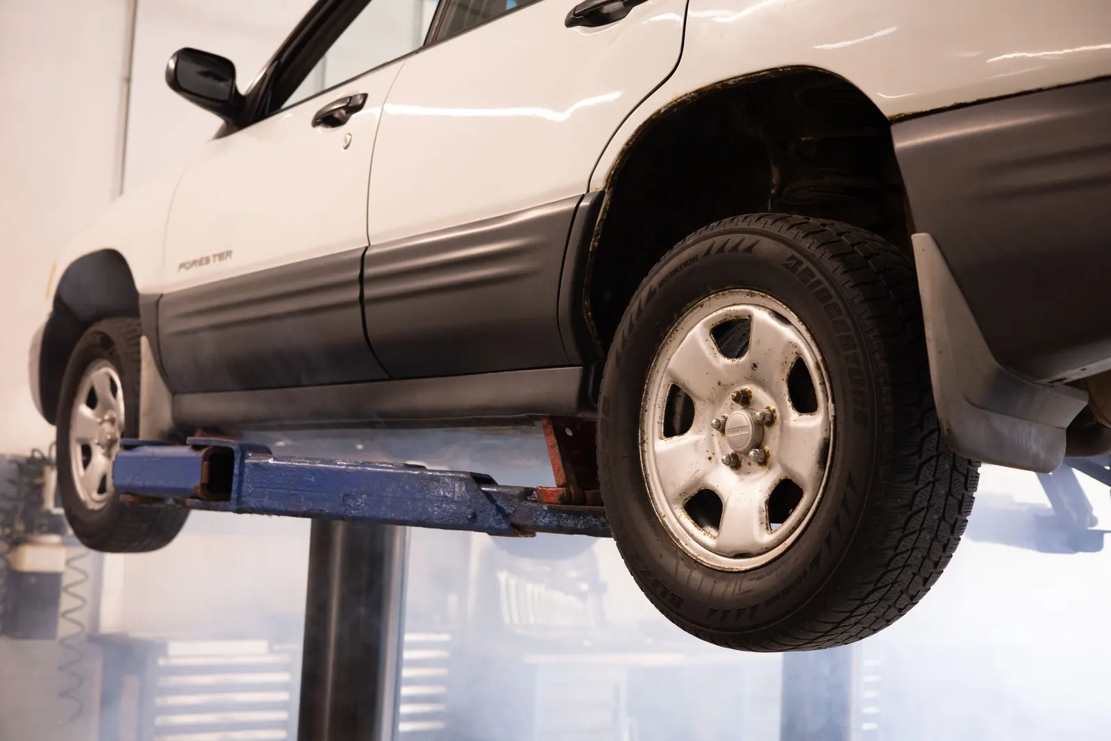 A car raised on a lift in a service bay