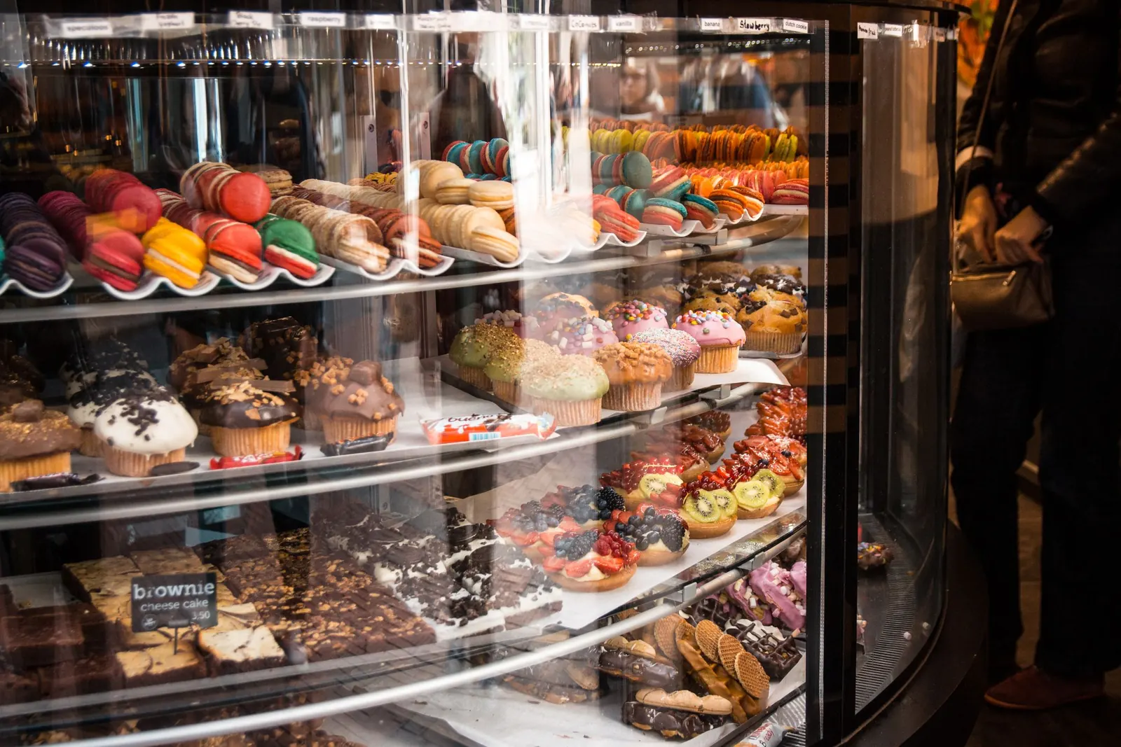 Pastries lined up behind a bakery display case