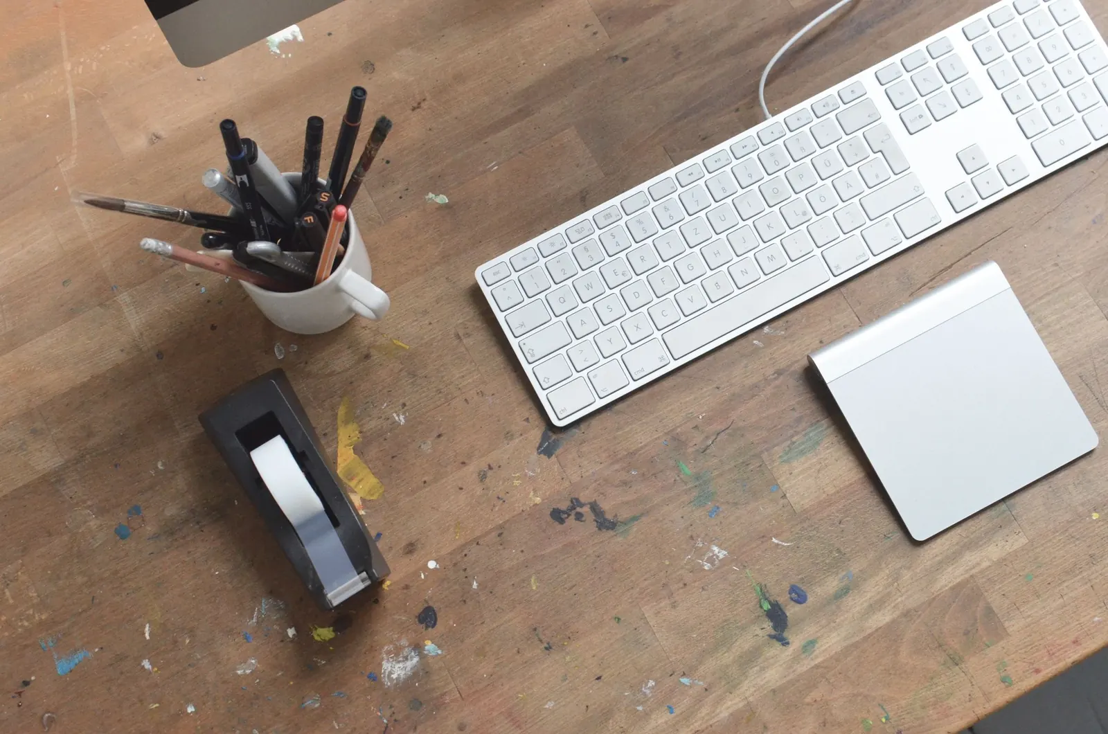 A working desk of tools, paper and paint marks