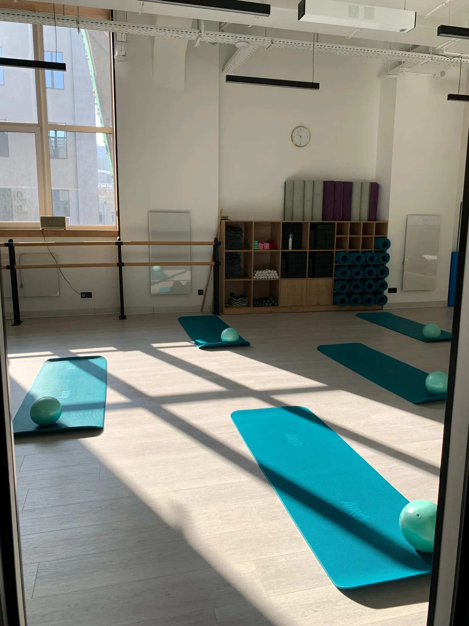 A sunlit studio with mats laid out before class