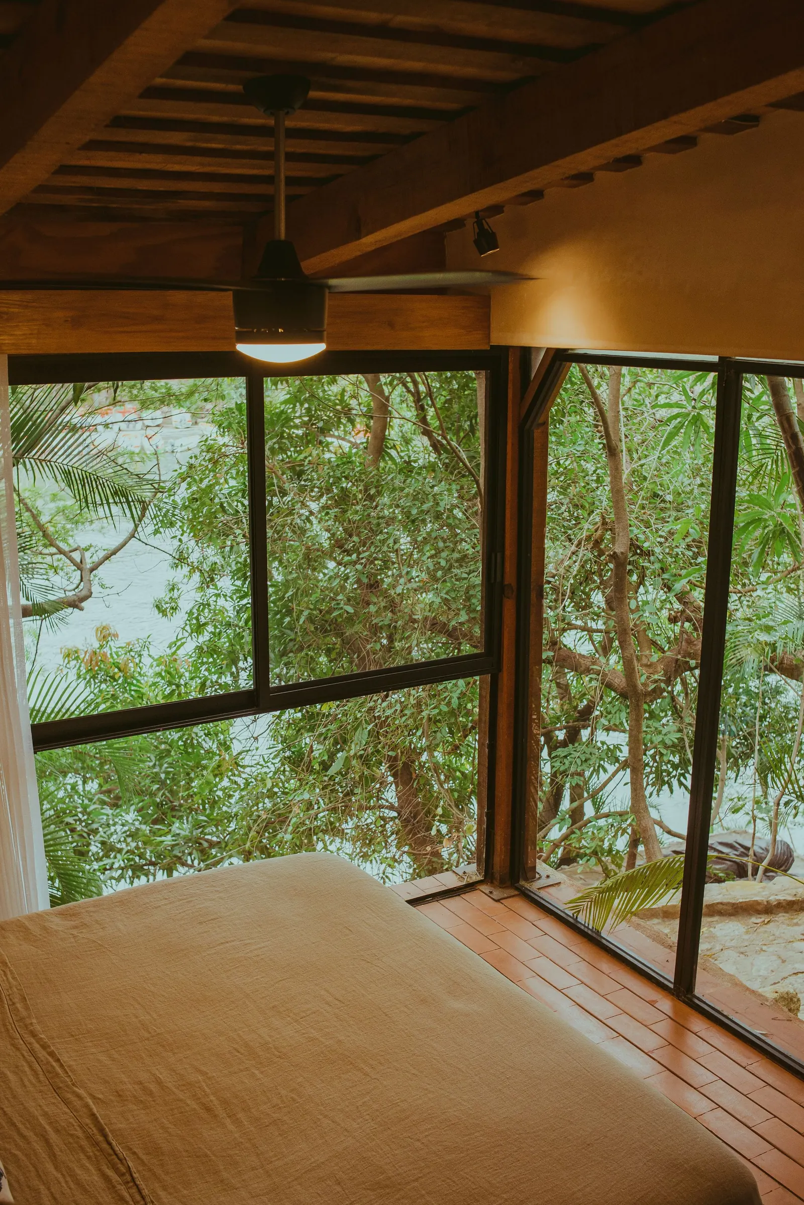 A quiet wood-lined bedroom overlooking a lake