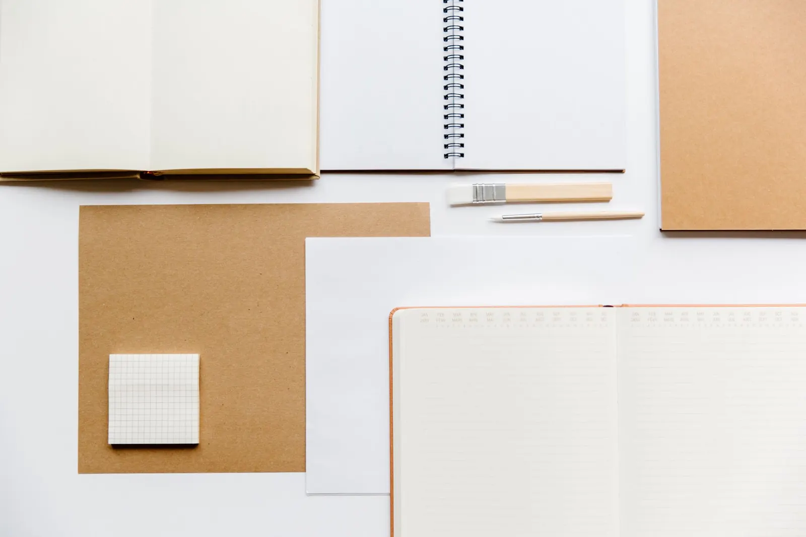 Notebooks and paper arranged neatly from above