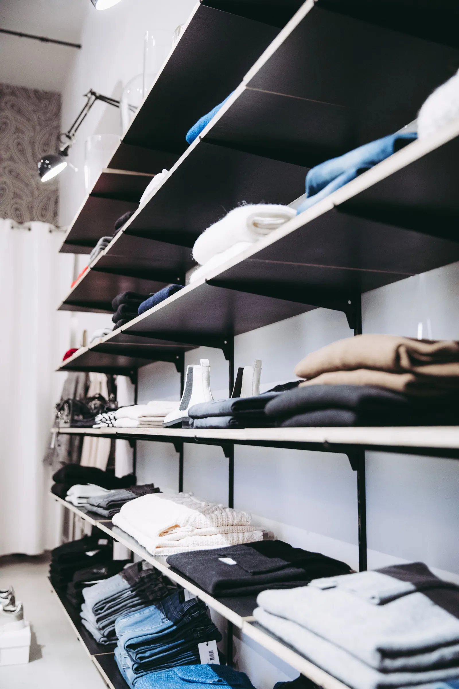 Folded goods arranged on simple black shelving