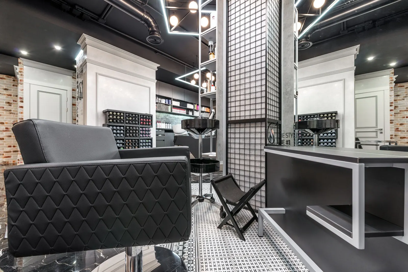A dark salon interior with leather chairs and mirrors