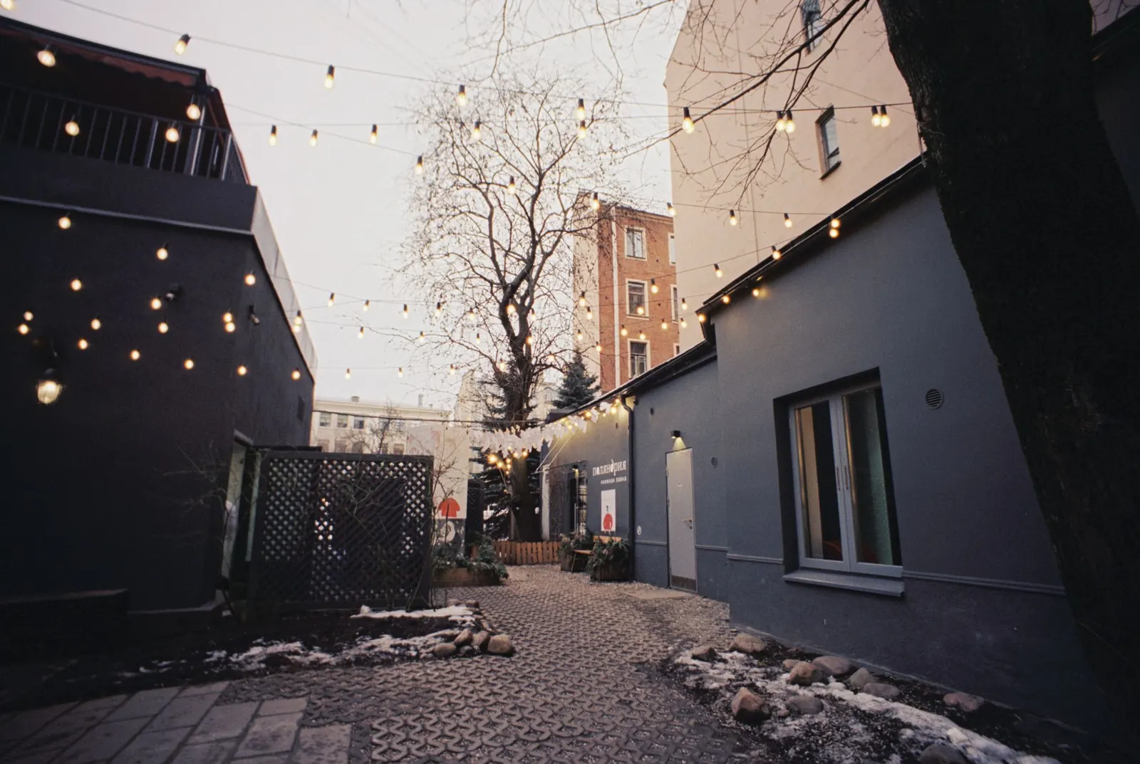 A courtyard strung with lights at dusk