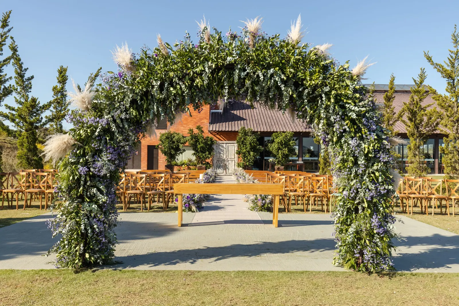 A floral arch and rows of chairs set outdoors