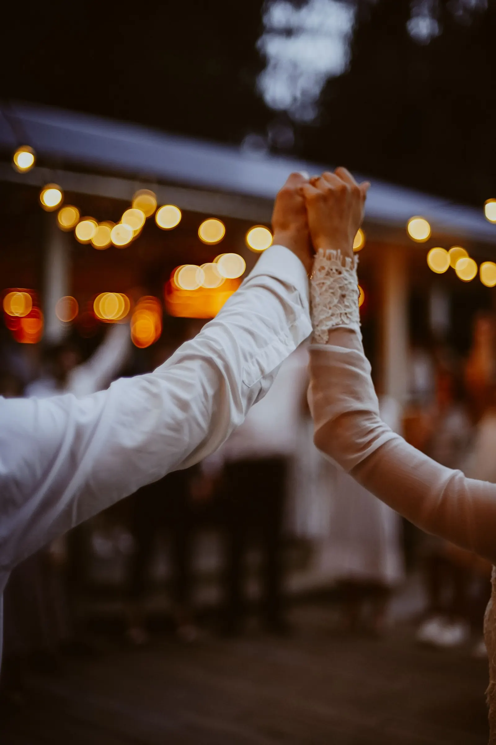 Two people dancing beneath warm evening lights